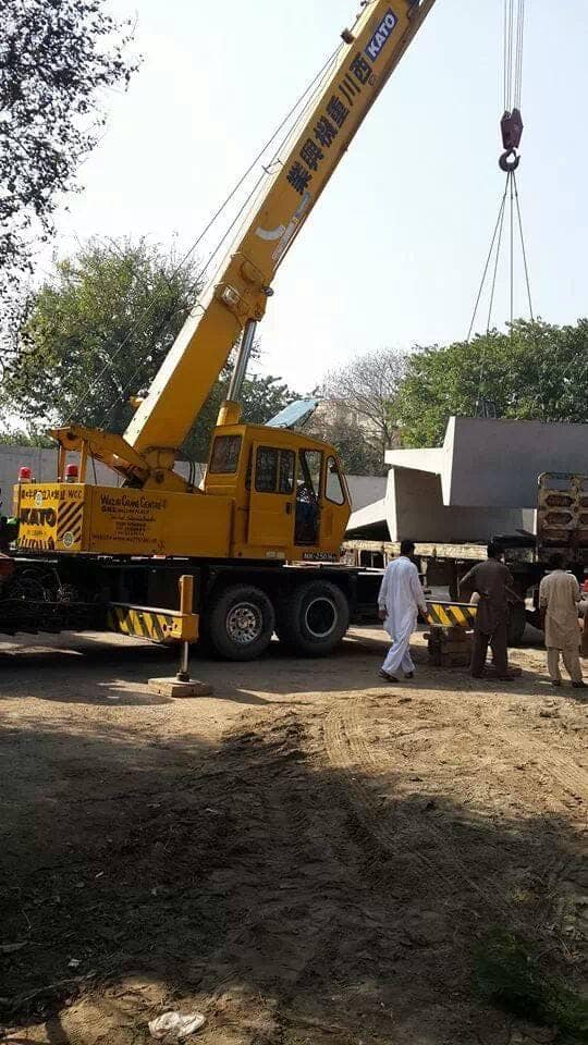 Truck-mounted crane lifting a concrete block